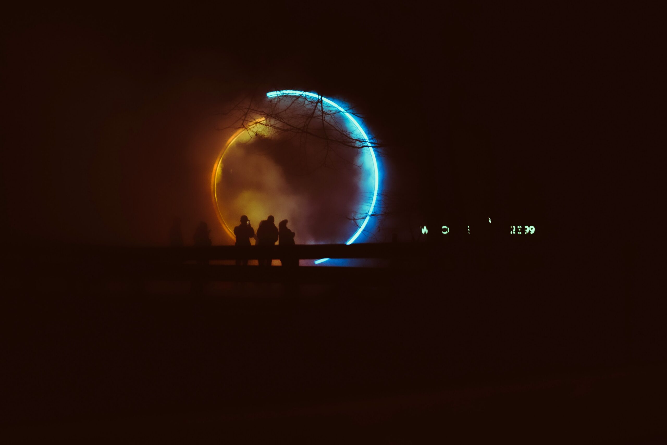 Millennials taking pictures of a light show.